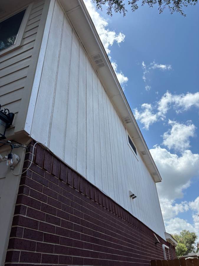 Stained vertical siding and soffit on a two-story wall